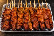 Grilled BBQ skewers in a foil tray